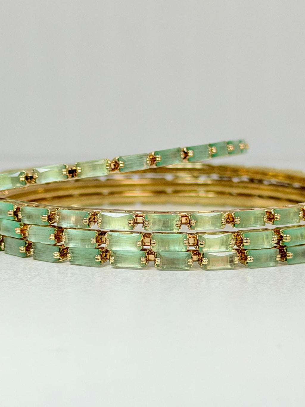 Stunning mint‑green crystal bangles set in gold‑tone metal