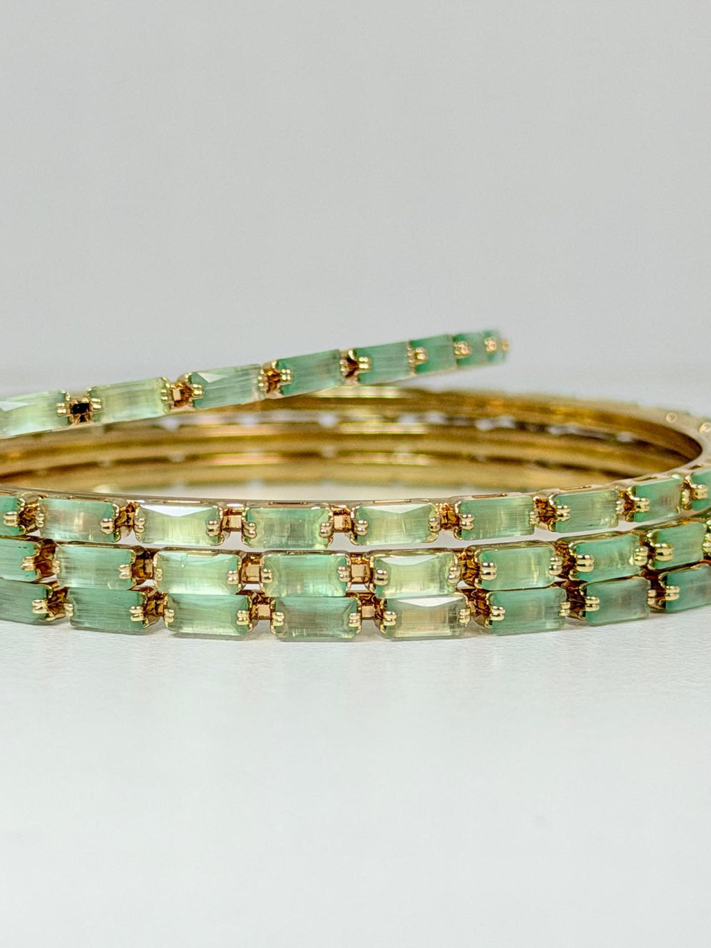 Stunning mint‑green crystal bangles set in gold‑tone metal