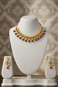 Stunning gold-toned kundan necklace & earring set with vibrant red & green bead drops