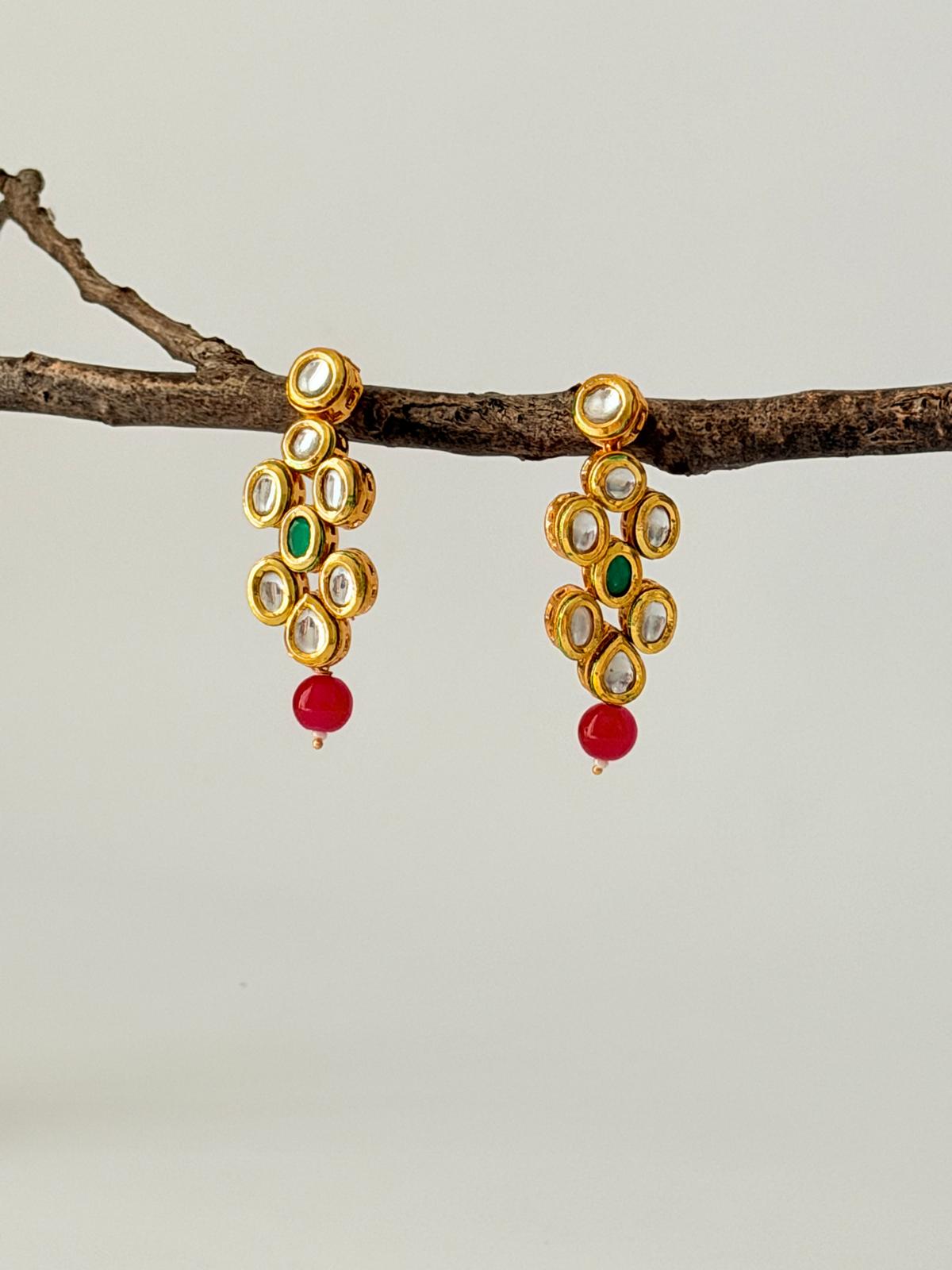 Stunning gold-toned kundan necklace & earring set with vibrant red & green bead drops