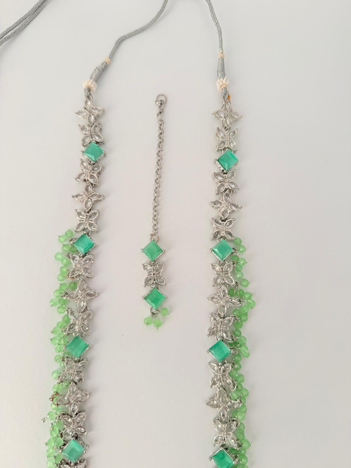 Stunning silver-toned necklace set with vibrant green gemstones