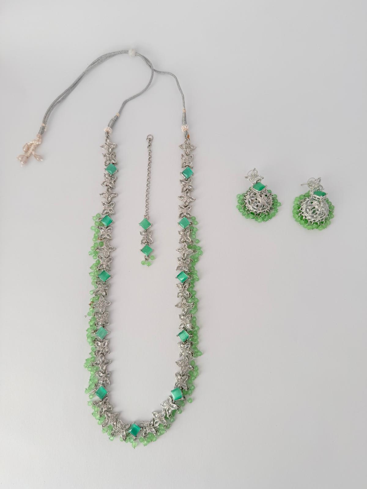 Stunning silver-toned necklace set with vibrant green gemstones